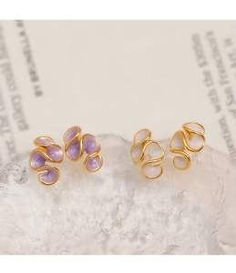 Détail de boucles d'oreilles en émail crème et violet avec bordure dorée sur base