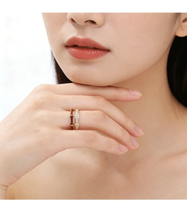 Détail de bagues superposées en émail avec zircons portées sur le doigt du mannequin