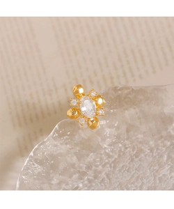 Macro shot of geometric gold rhombus brooch with sparkling clear zircon inlay