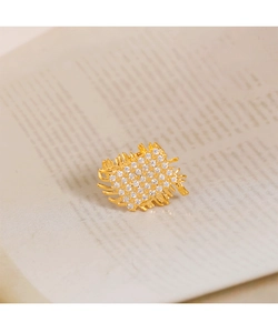 Macro shot of gold rectangle brooch with clustered crystals and woven metal borders