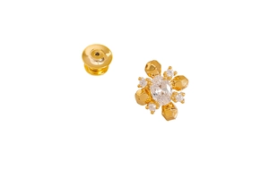 Macro detail of geometric gold brooch featuring an oval zircon and polished metal clasp