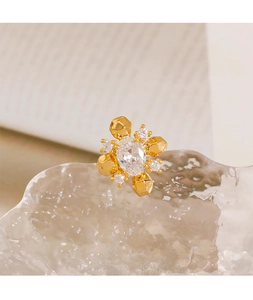 Macro shot of gold geometric flower stud with oval zircon on a crystal base