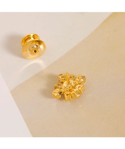 Detail of gold geometric diamond brooch base and butterfly clutch with sparkling finish