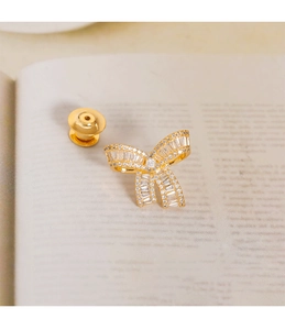 Close-up of golden bow brooch with sparkling cubic zirconia on an open book