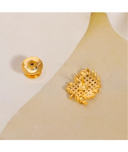 Macro detail of luxury geometric brooch back showing gold texture and butterfly clasp