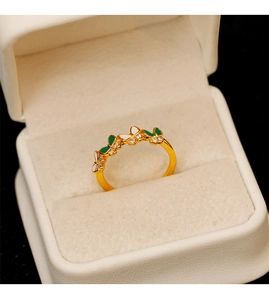 Vue détaillée d'une bague papillon dorée avec émail vert et blanc et strass brillants