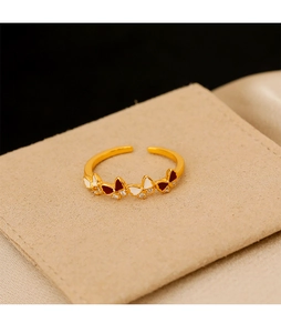 Vue macro d'une bague papillon dorée avec ailes en émail et détails en zircons blancs