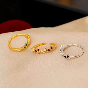 Lot de trois bagues papillon en émail avec zircons sur fond de soie couleur champagne