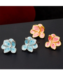 Detailed close-up of vintage enamel flower studs in blue and pink pastel shades