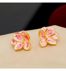 Detailed macro view of pink enamel flower earrings with golden edges and pearl centers