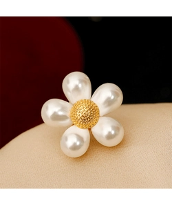 Détail d'une broche marguerite de luxe avec pétales en perles et cœur en métal doré