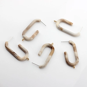 Five U-shaped acetate resin earring components with amber marble texture and gold studs