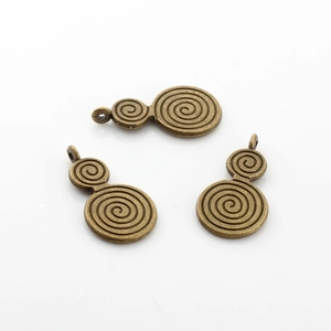 Macro detail of antique bronze spiral pattern pendants for DIY jewelry making sets