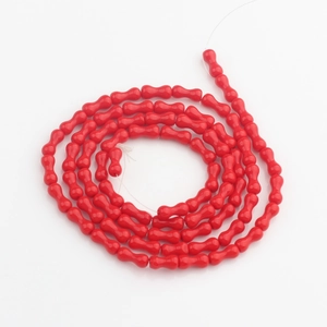 Dettaglio macro di perline di vetro a cristallo rosso a forma di osso per gioielli