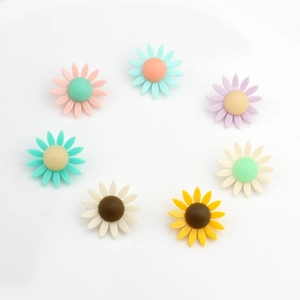 Sept boucles d'oreilles marguerites colorées en résine mate disposées en cercle symétrique