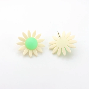 Détails macro des boucles d'oreilles marguerites en résine avec centre vert