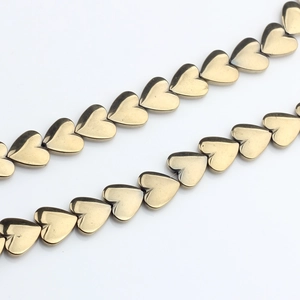 Macro shot of 10mm golden heart-shaped hematite beads with high metallic luster for DIY