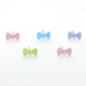 Pastel macaron bow earrings set in pink blue purple green on a white reflective surface