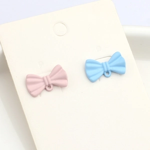 Minimalist macaron bow earrings in pink and blue matte resin on white background