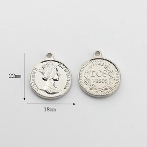 Macro shot of silver alloy coin charms showing Queen portrait and 18mm diameter measurement
