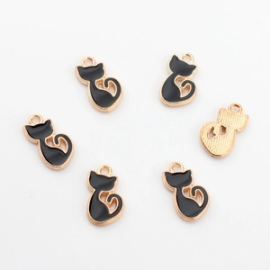 Detail view of cat charms with black enamel and textured gold back for DIY jewelry