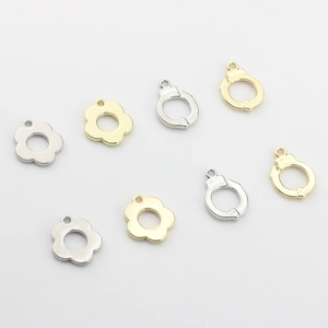 Macro view of hollow plum blossom and handcuff pendants in gold and silver finishes