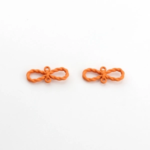 Détail de breloques nœuds orange avec finition mate et deux trous de connexion
