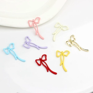 Close-up of assorted colorful bow pendants for DIY jewelry making in various finishes