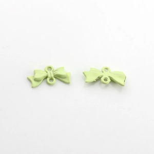 Gros plan sur des pendentifs nœuds vert pastel mats pour la création de bijoux DIY