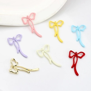 Macro view of colorful painted bow pendants in macaron tones for DIY jewelry making