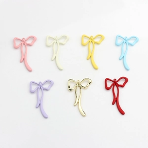 Detail view of colorful matte and gold finish bow pendants for DIY jewelry making