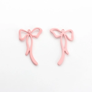 Macro detail of pink matte lacquered metal bow pendants for DIY jewelry making