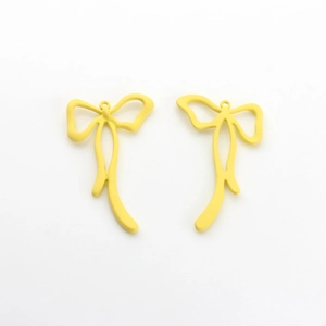 Macro view of matte yellow bow-shaped alloy pendants for DIY earring and necklace making