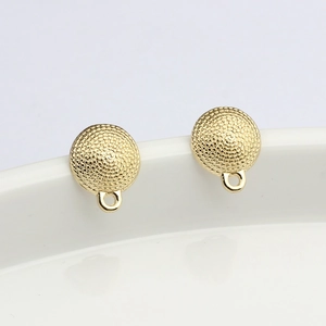 Gros plan de connecteurs de bijoux dorés ronds texturés pour boucles d'oreilles DIY