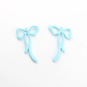 Detail of light blue matte painted bow pendants with long tassels for DIY jewelry