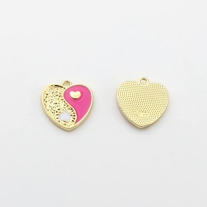 Close-up of alloy heart Yin Yang charm with pink enamel drip and gold grainy texture