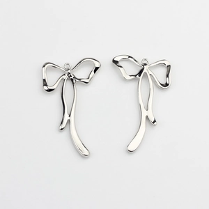Close-up of polished silver bow charms for DIY jewelry making with smooth finish