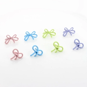 Macro shot of matte macaron color bow studs in pink, blue, green and purple hues