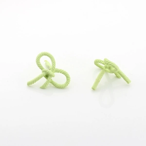Detail of light green matte bow earrings with twisted rope texture on a white background
