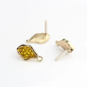 Detailed view of irregular gold leaf earring base with yellow beads and hanging loop