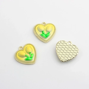 Détail de breloques tulipes en cœur avec émail jaune et dos métallique texturé