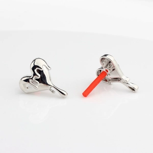 Detail of silver liquid metal heart earrings with mirror finish and red protective caps