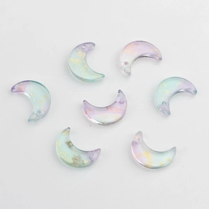 Vue détaillée de breloques lune en verre avec dégradé de couleurs et paillettes dorées