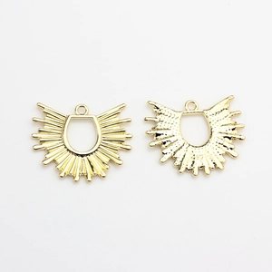 Macro shot of sunburst gold fan pendants showing smooth front and textured logo back