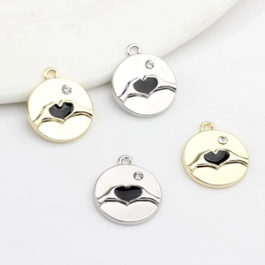Golden and silver heart hand gesture charms with zircon stones and black enamel inlay
