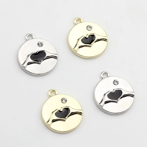 Detail of alloy heart hand pendants with black enamel and zircon for DIY jewelry
