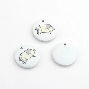 Detail von runden Holzanhängern mit Origami-Schwein-Drucken und Bohrlöchern für DIY-Schmuck