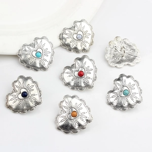 Macro detail of heart-shaped conchos with colorful beads and vintage silver finish