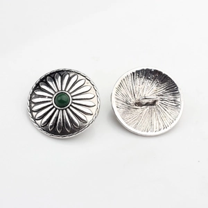 Close-up of vintage silver sunflower shank buttons with green faux gemstone centers