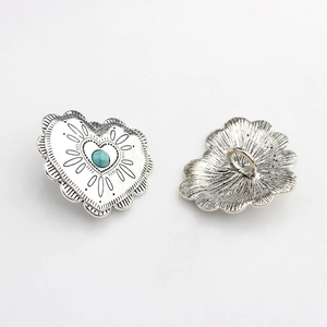 Macro detail showing vintage silver heart button with turquoise inlay and sewing shank